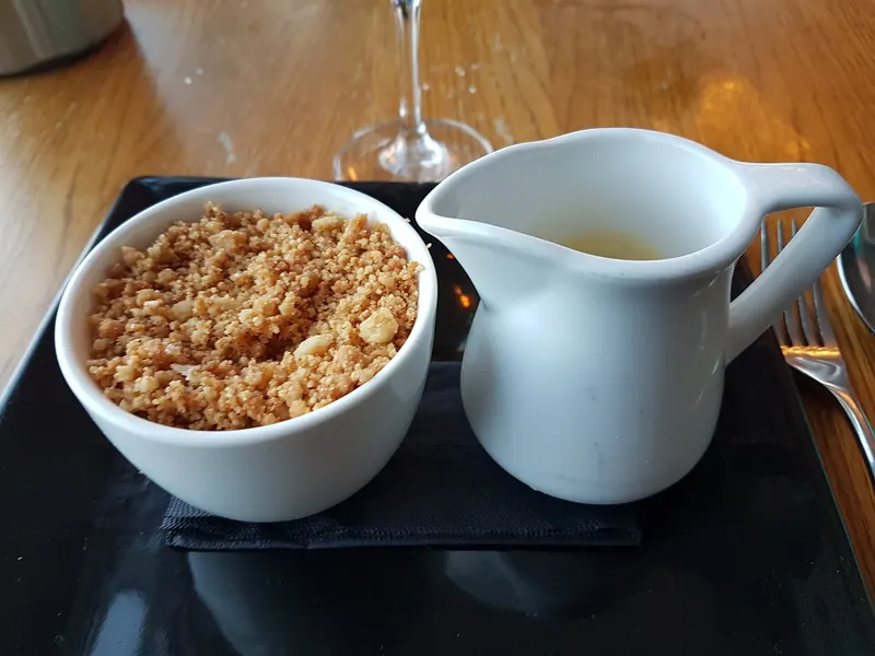 Apple and rhubarb crumble with a jug of custard