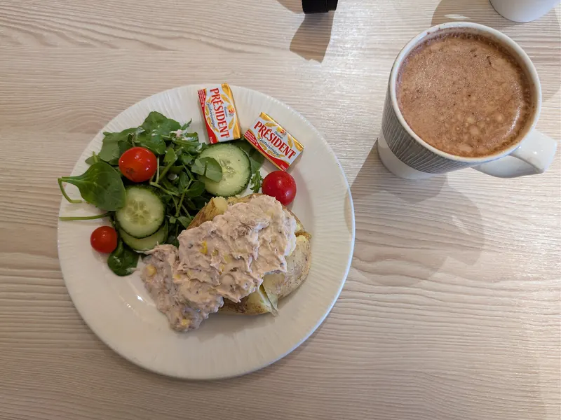 Jacket potato with tuna, sweetcorn and mayonnaise and a side salad, in a café