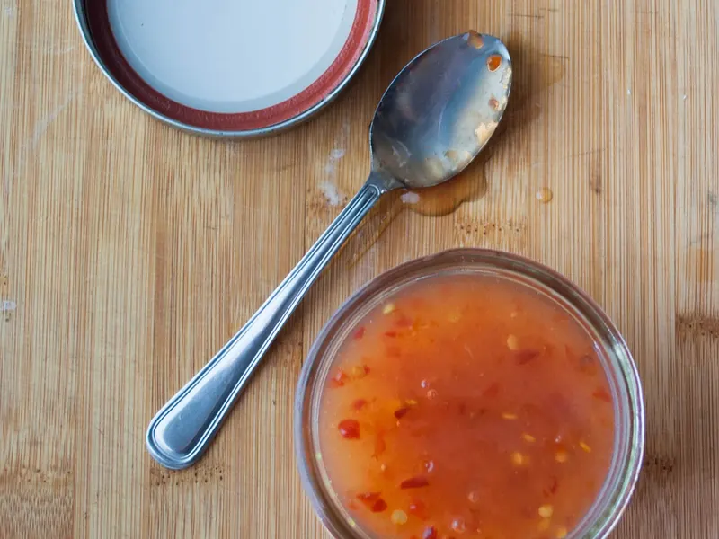 Sweet chilli sauce in a small glass dish with a spoon